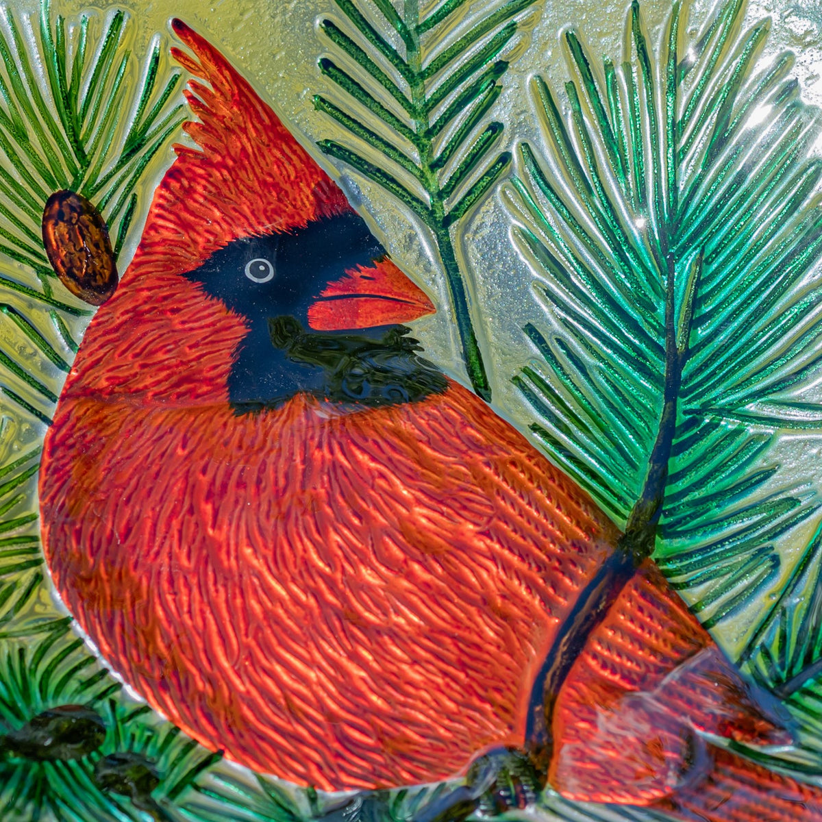 Detailed view of the red cardinal painted among evergreen branches on glass
