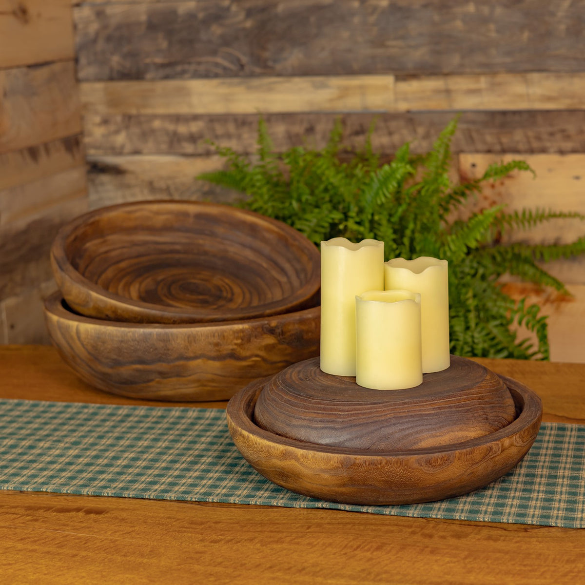 Wooden nesting trays displayed on a table, with candles in the front tray.