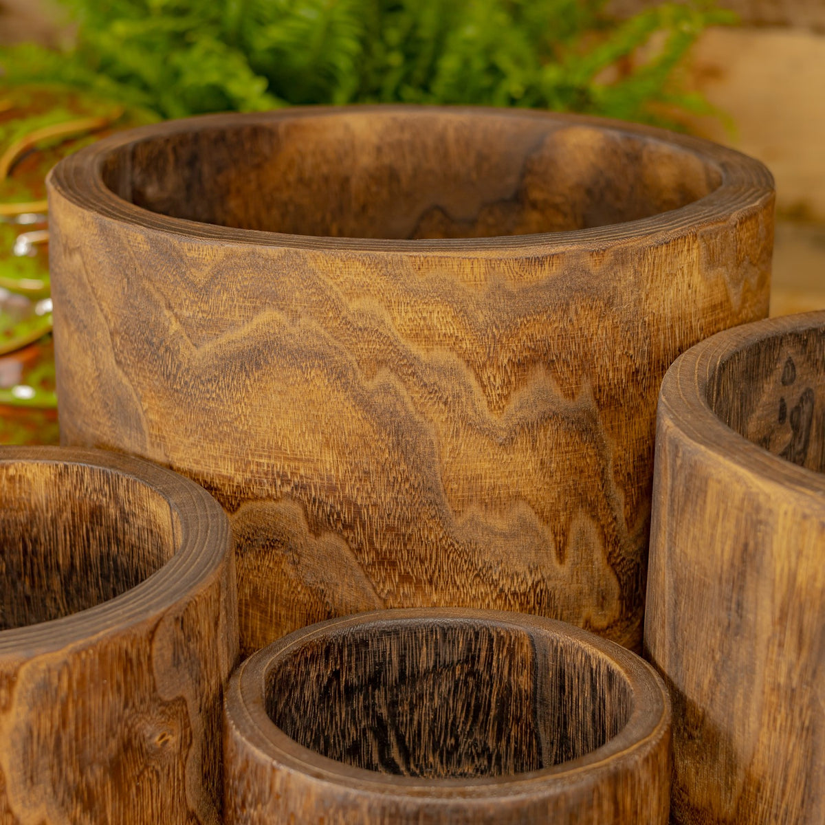 Several round wooden bowls grouped together, showing their thick rims and varied swirling grain.