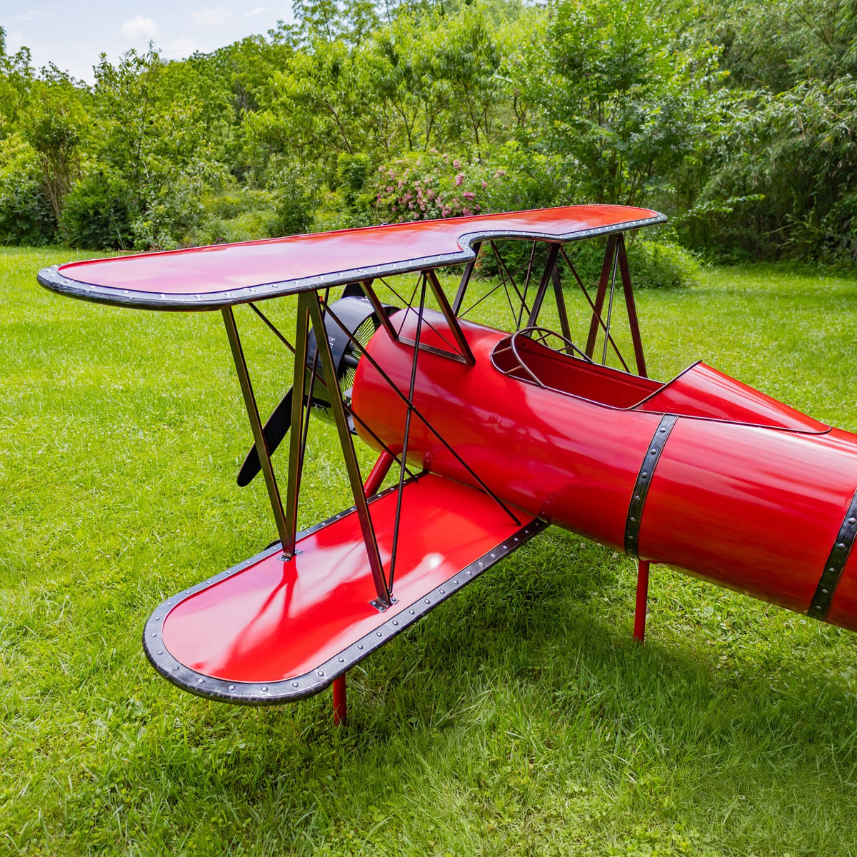 Red biplane wings and cockpit seen from a raised rear angle