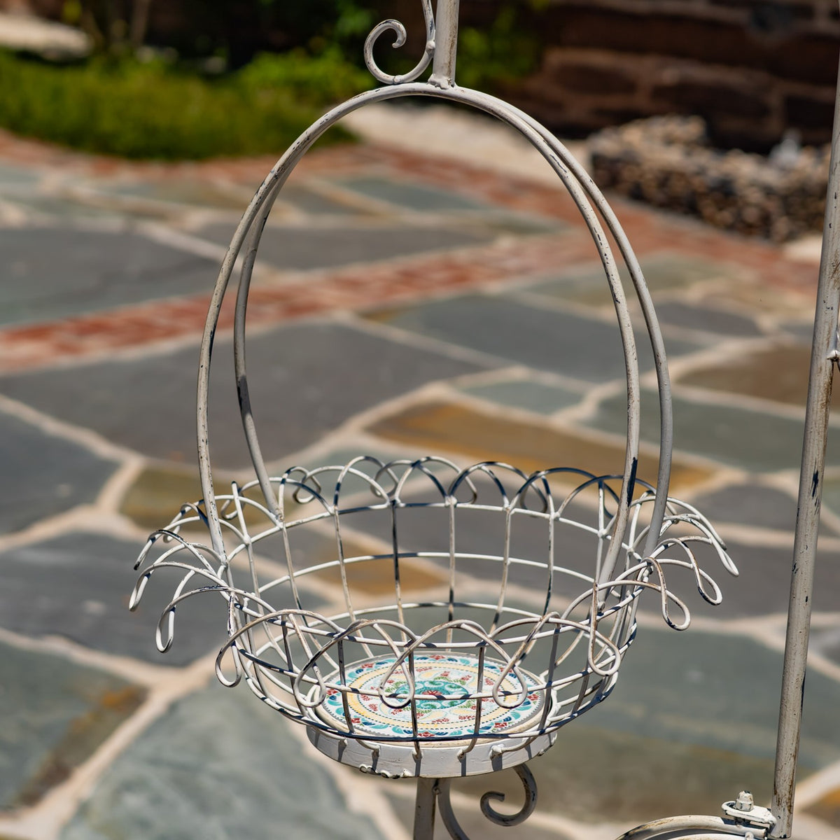 Close view of a wire basket with a circular handle and a colorful patterned base.