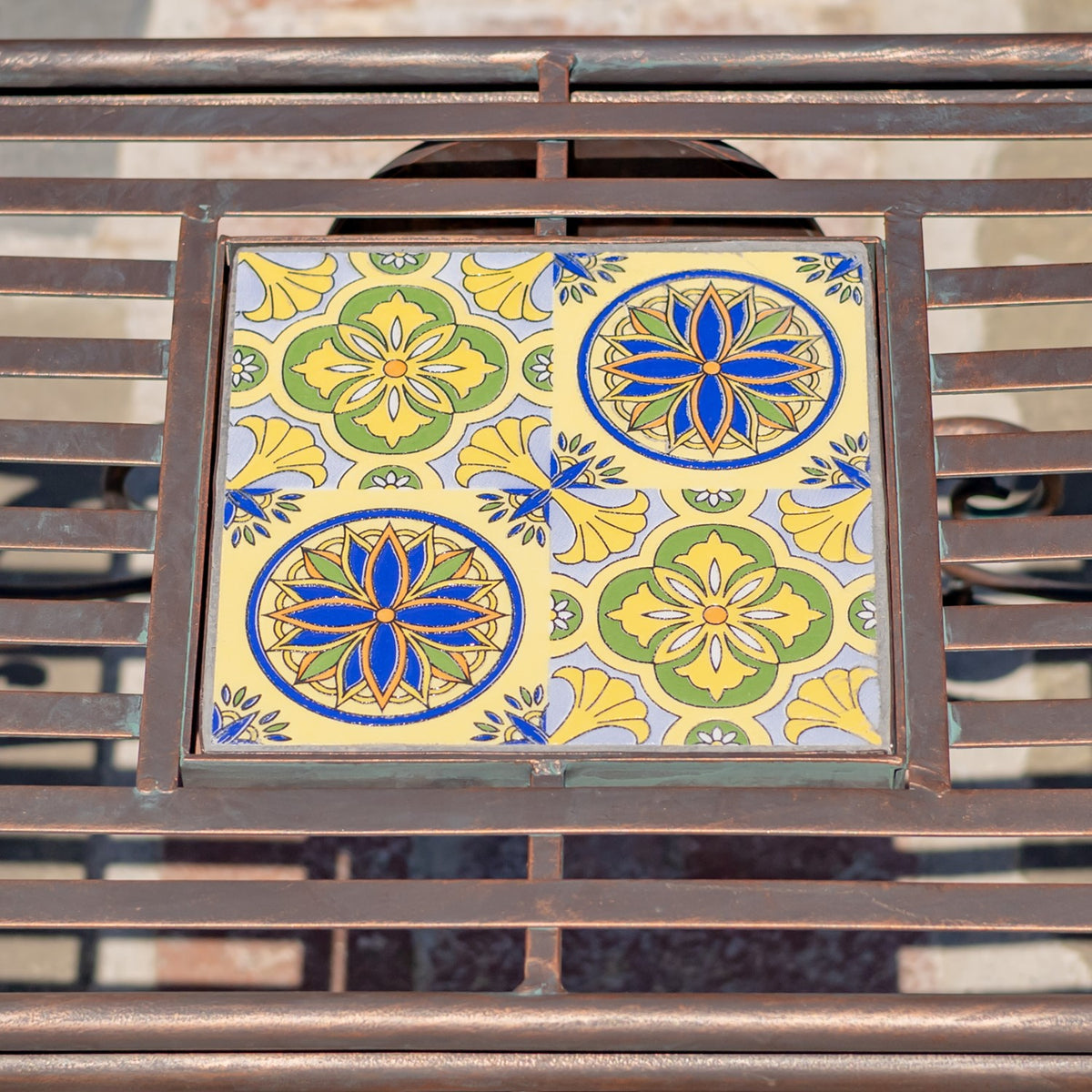 Close-up of a colorful floral mosaic tile panel set within a dark metal chair frame.