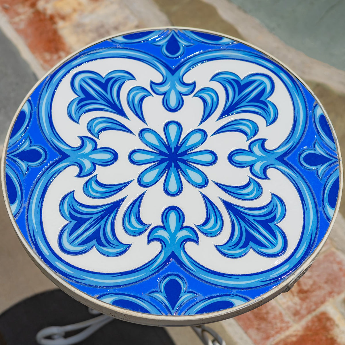 Round tabletop with an ornate blue-and-white floral mosaic pattern and a narrow metal rim.