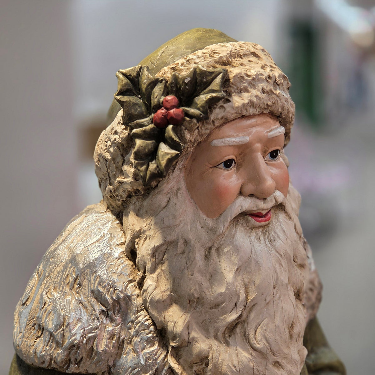 Close-up of Santa's face and holly detail on the antique green hat