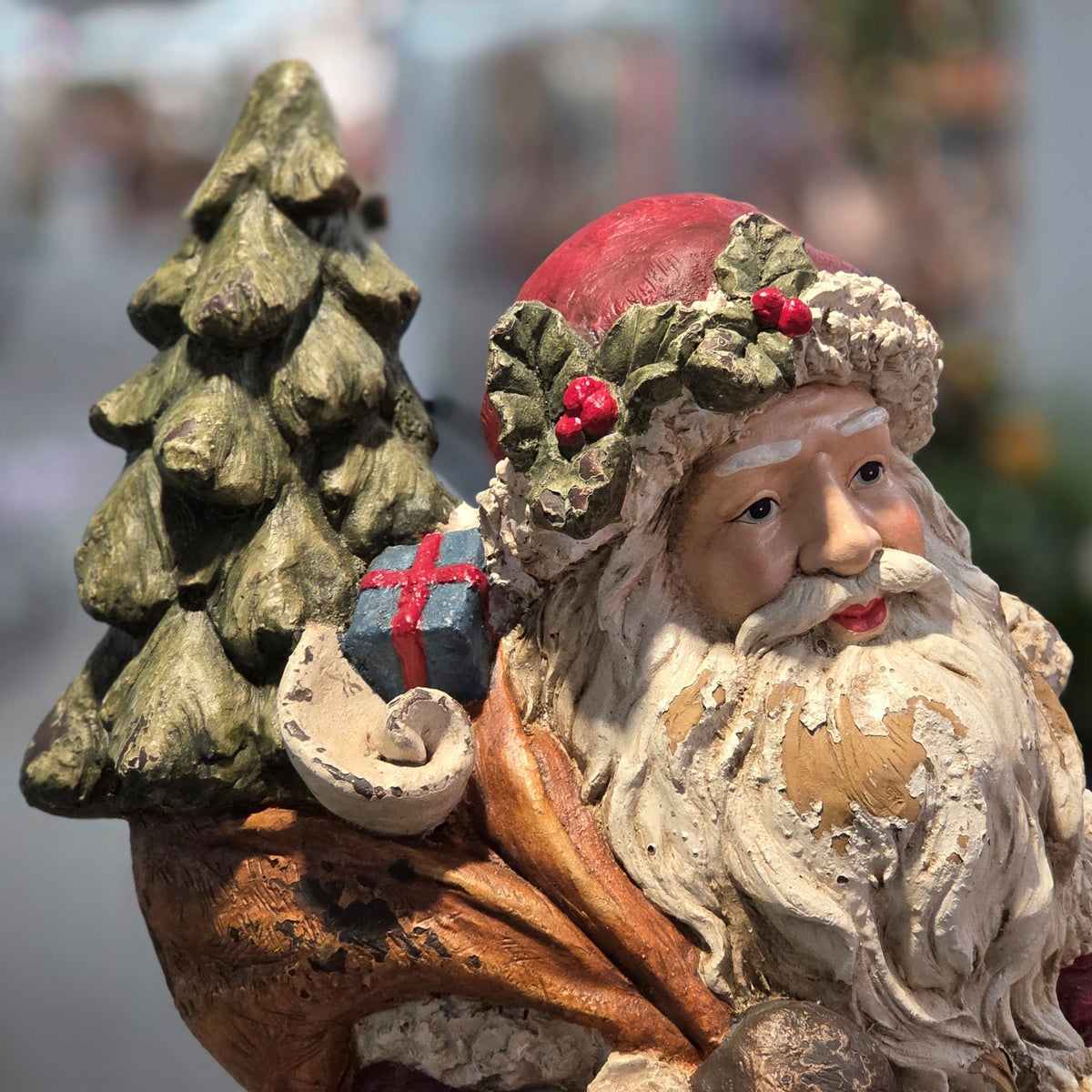 Close-up of Santa beside the tree and a small wrapped gift