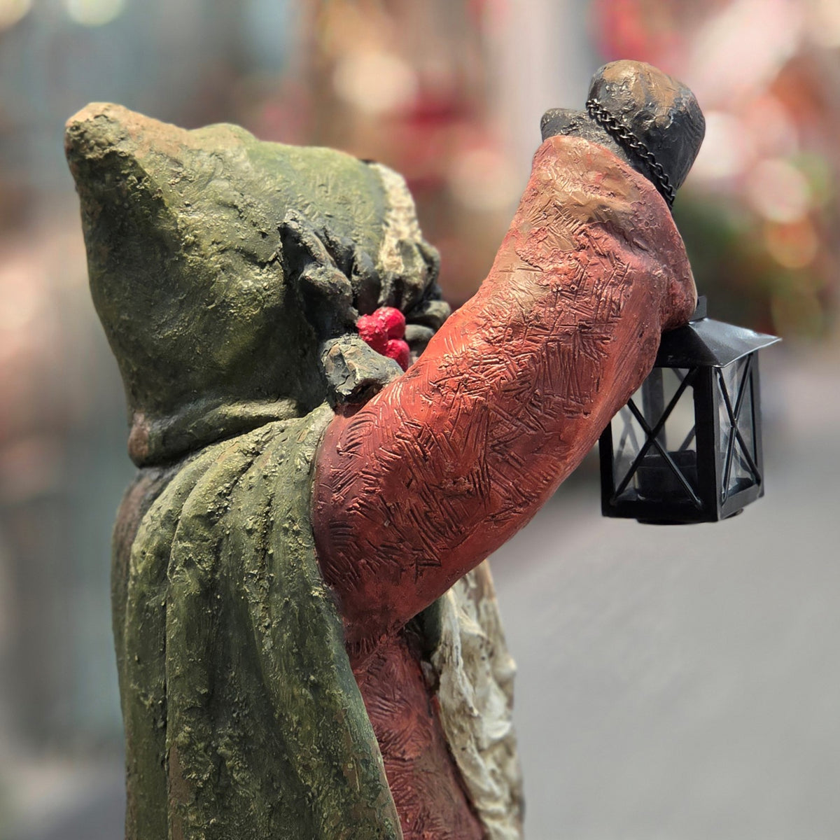 Rear-side view of Santa's raised arm holding the lantern