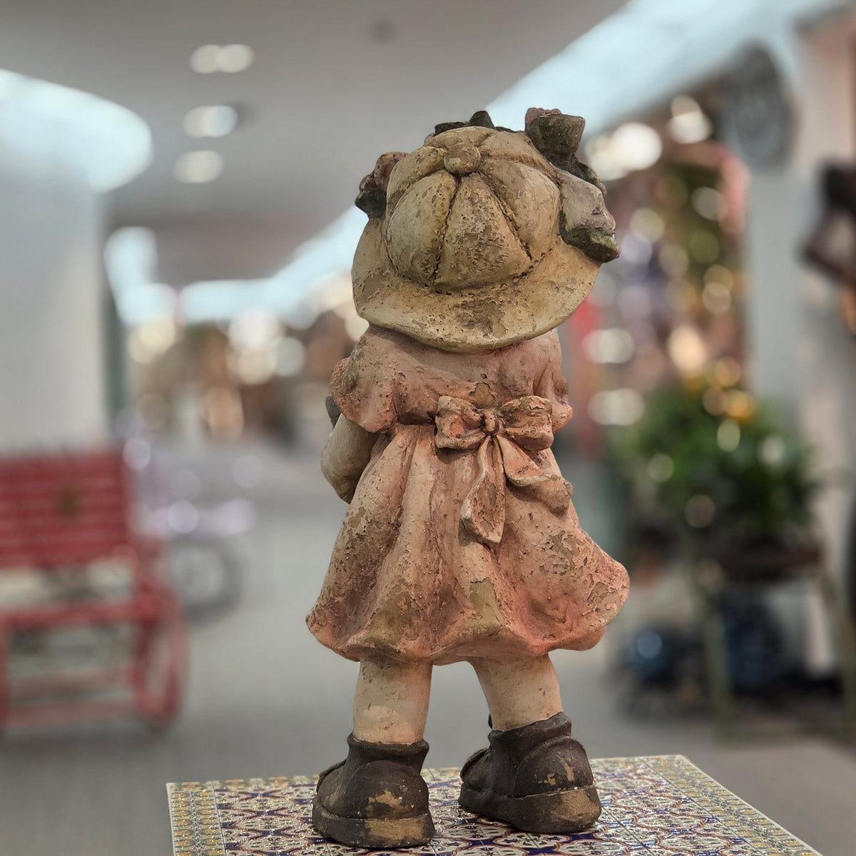 Rear view of the girl figurine showing her dress bow and boots