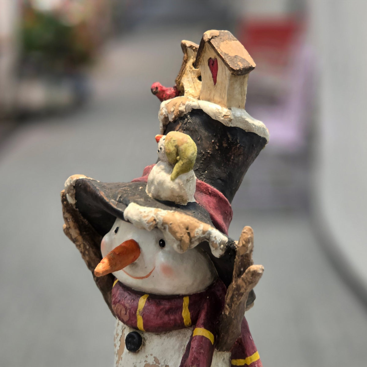 Angled close-up of the snowman's face, hat, and striped scarf