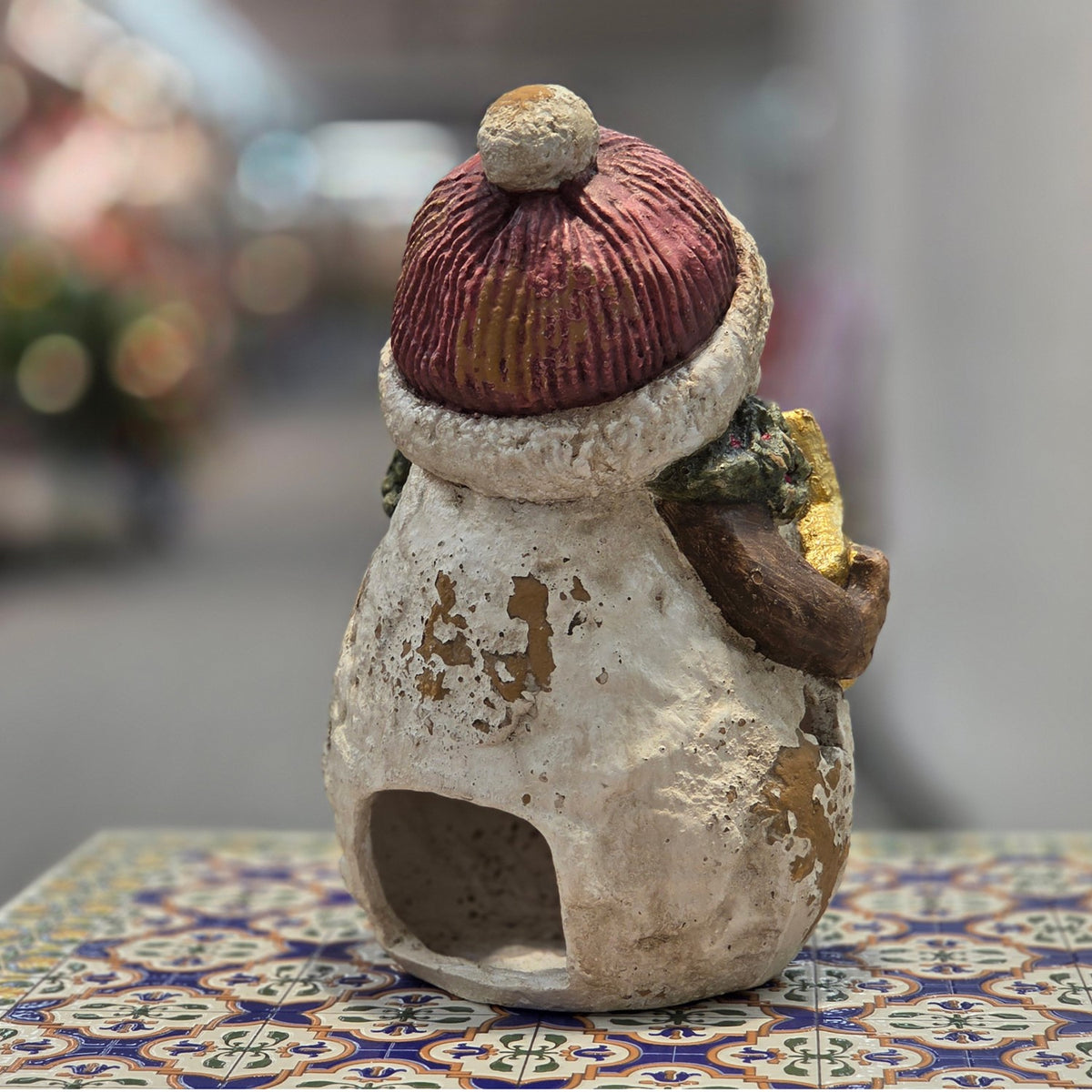 Rear view of the distressed snowman figurine showing its hollow base