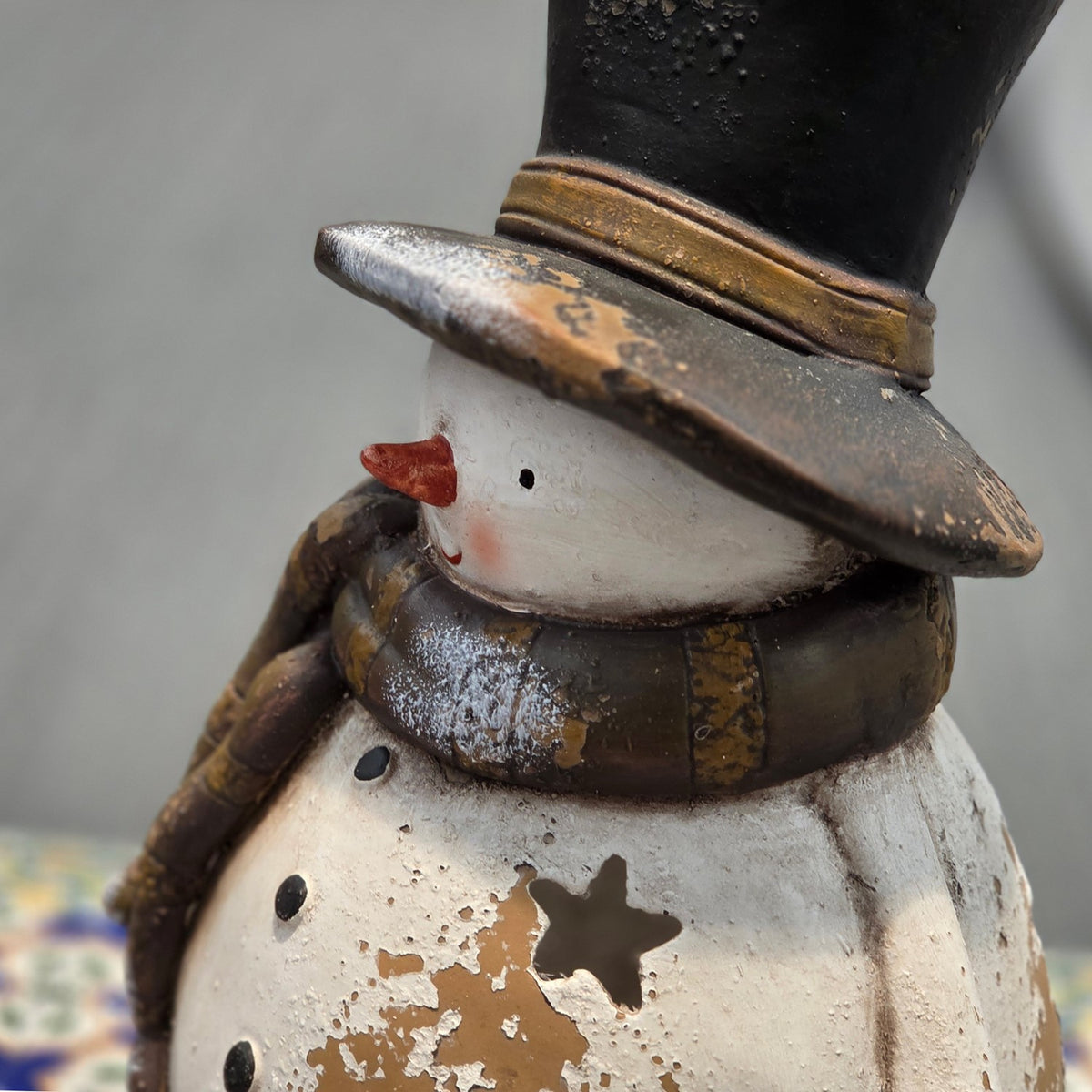 Close view of the snowman's hat, face, scarf and star cutout