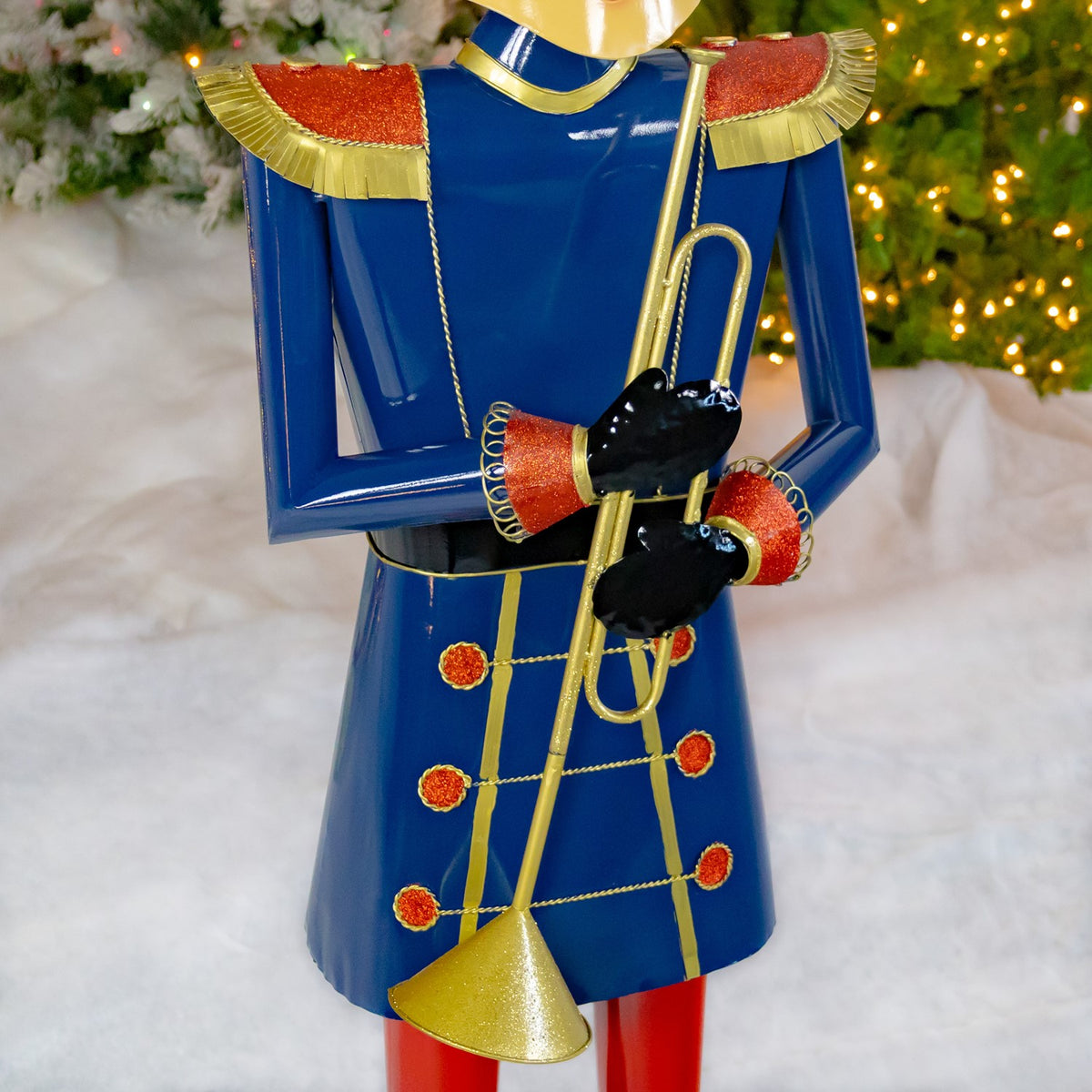 Close-up of the blue uniform, gold trumpet and glittered red-and-gold shoulder details