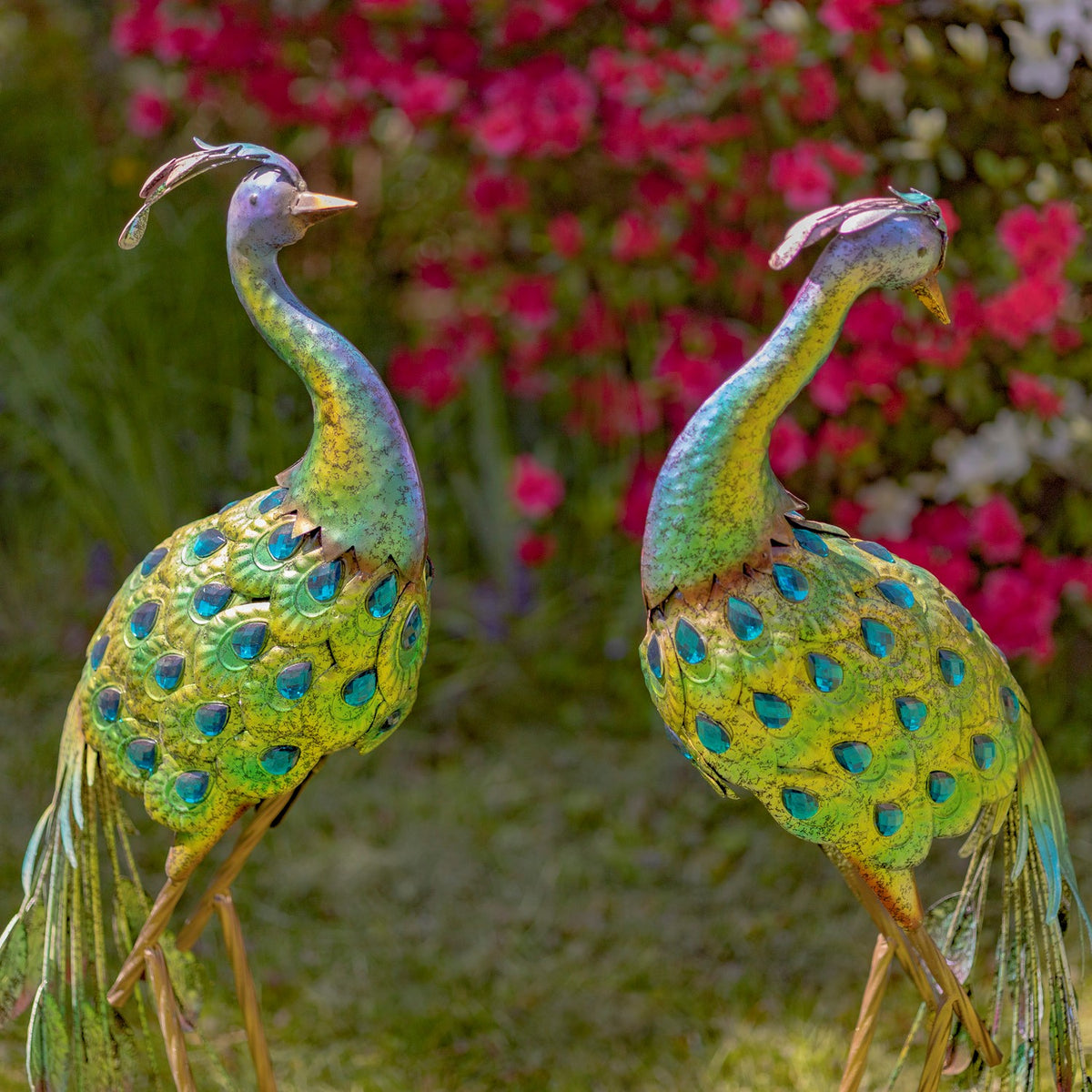 Two colorful peacock statues shown close together outdoors