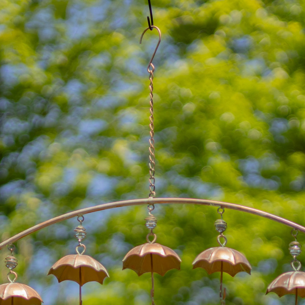 Close view of umbrella details on a hanging copper wind chime outdoors