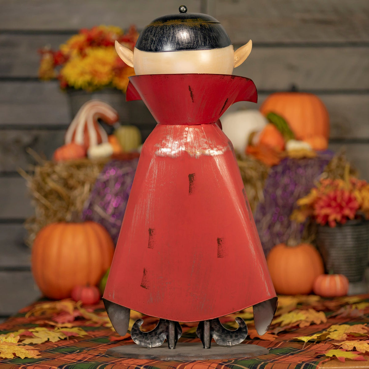 Rear view of the vampire figurine showing its red cape and round base
