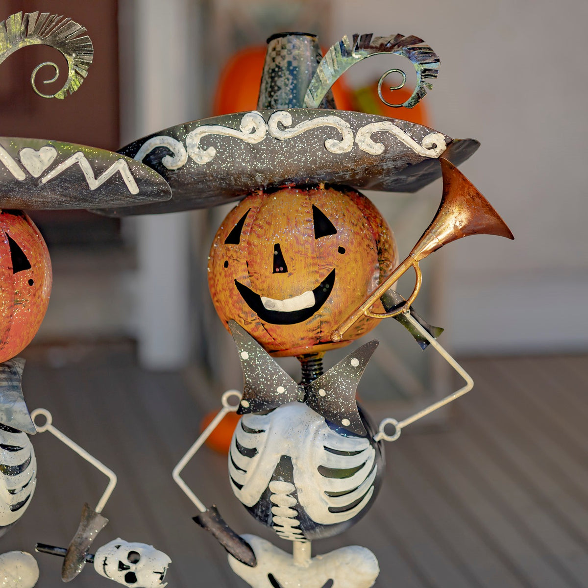 Close-up of a pumpkin-headed skeleton figurine holding a trumpet