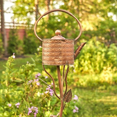 Angled view of the teapot birdhouse showing its spout and garden stake
