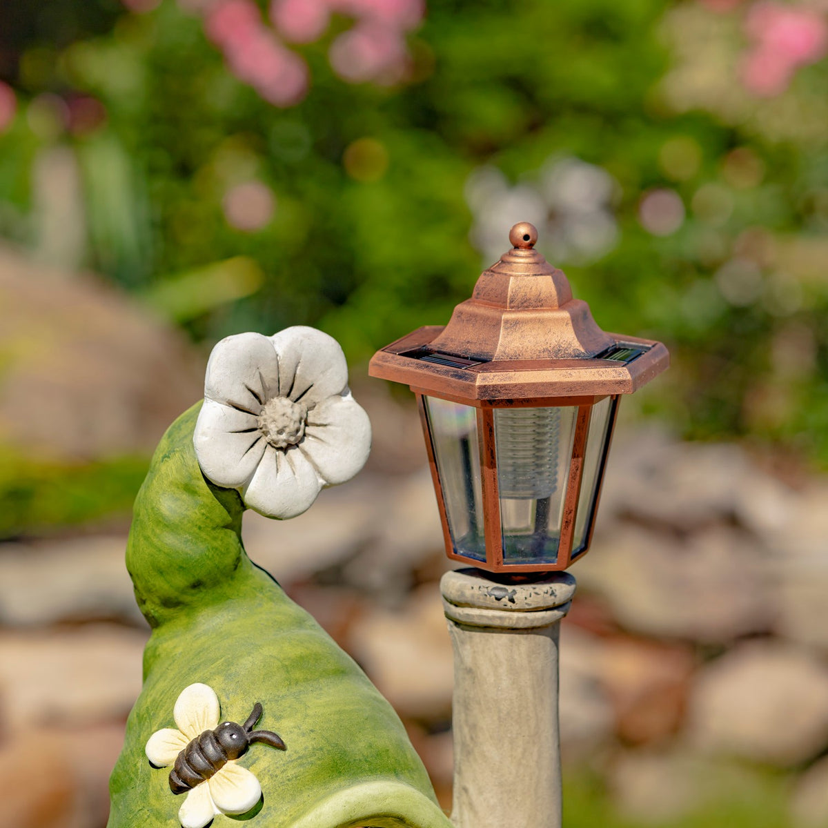 Close-up of a white flower detail and copper-colored solar lantern