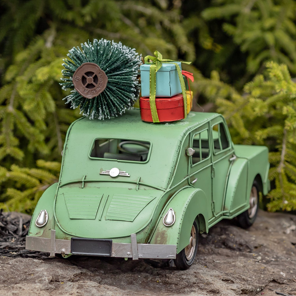 Rear three-quarter view of the light green car with roof tree and presents