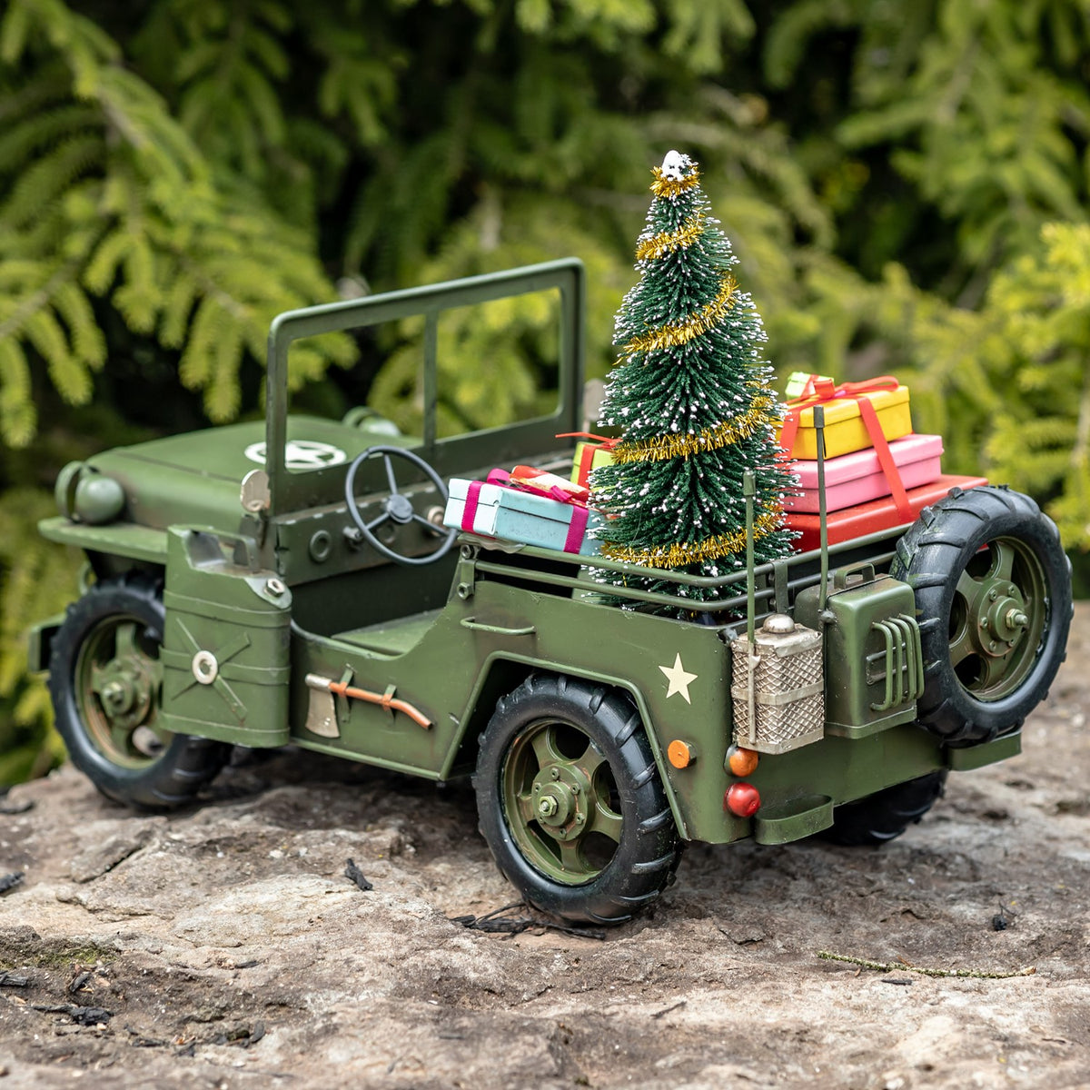 Army-green military vehicle with Christmas tree and gifts, angled rear view