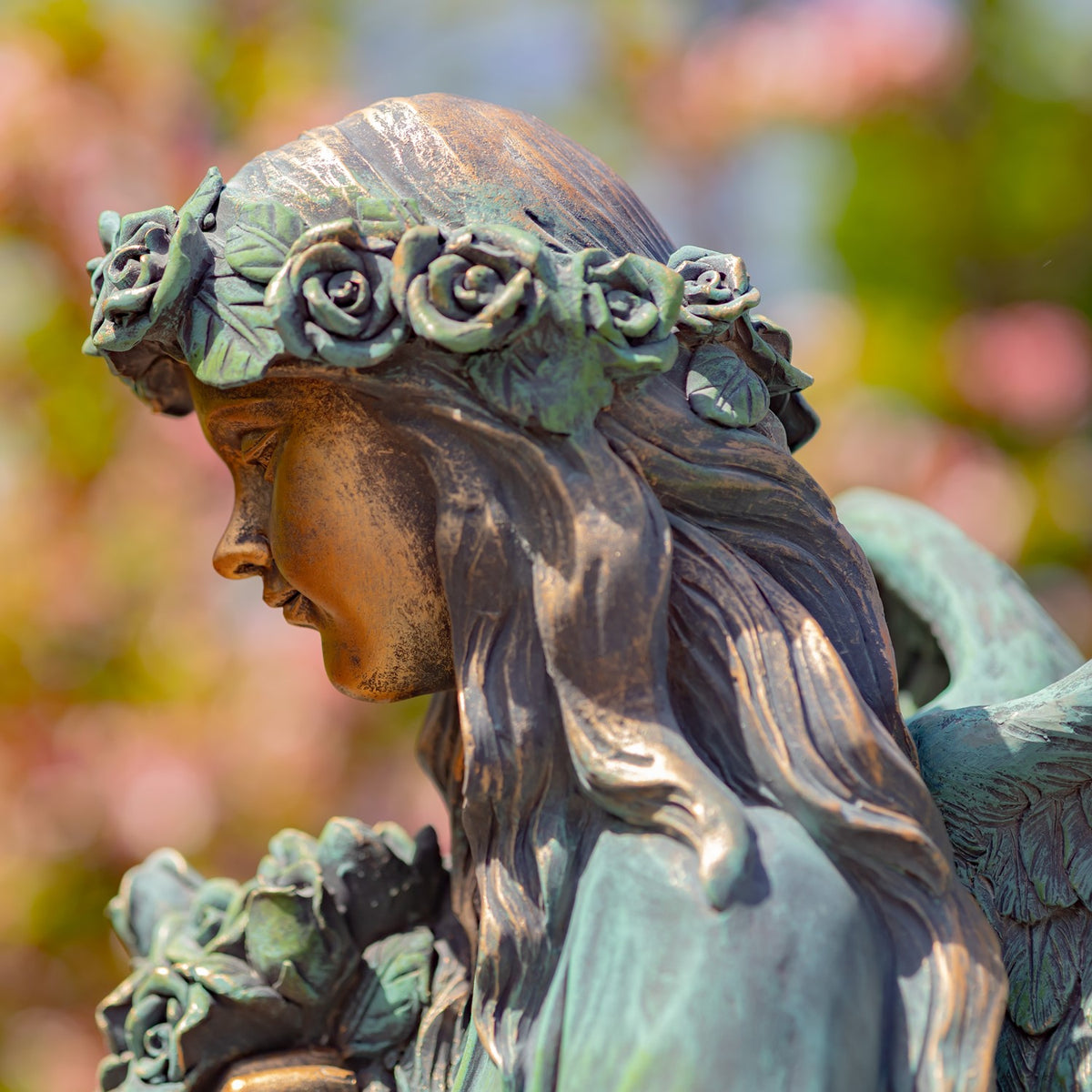 Close-up of the angel's flower crown, face, flowing hair, and bouquet.