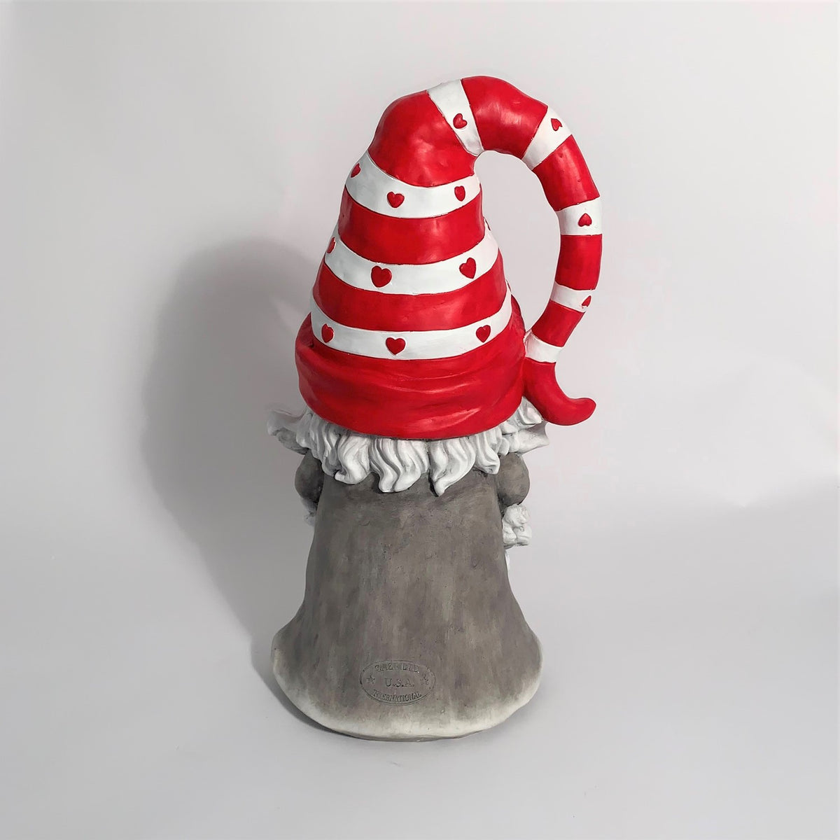 Rear view of a Valentine gnome showing its red striped hat and grey robe