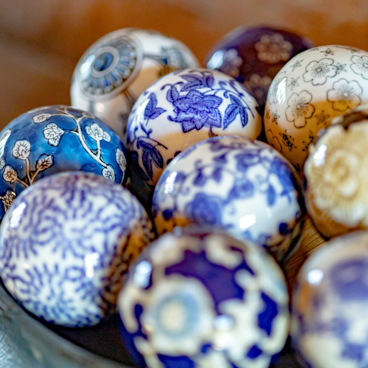 A cluster of patterned ceramic balls, including blue floral designs and a turquoise ball with pale leaf motifs.