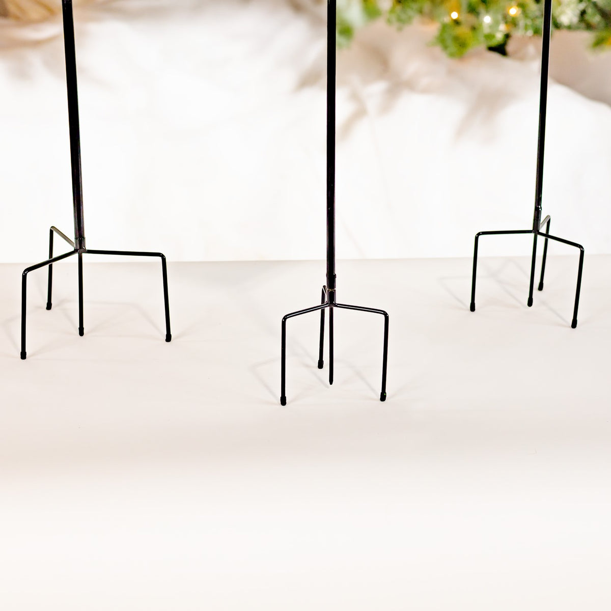 Close view of the three black metal stake bases on a light floor