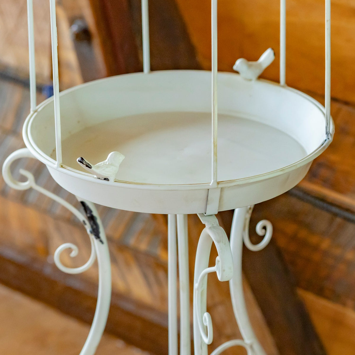 White circular tray with small bird accents, vertical cage bars, and curled iron legs.