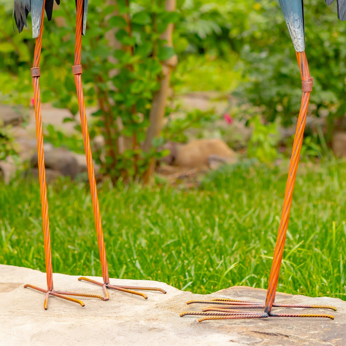 Close-up of slender egret legs and freestanding metal bases on stone