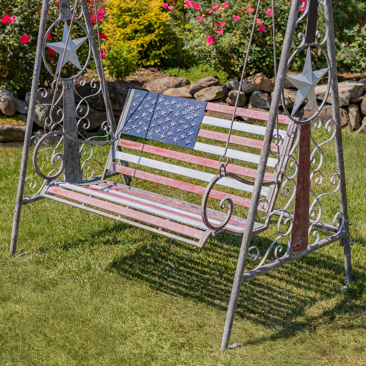 American flag swing bench shown from the front at an angle on grass