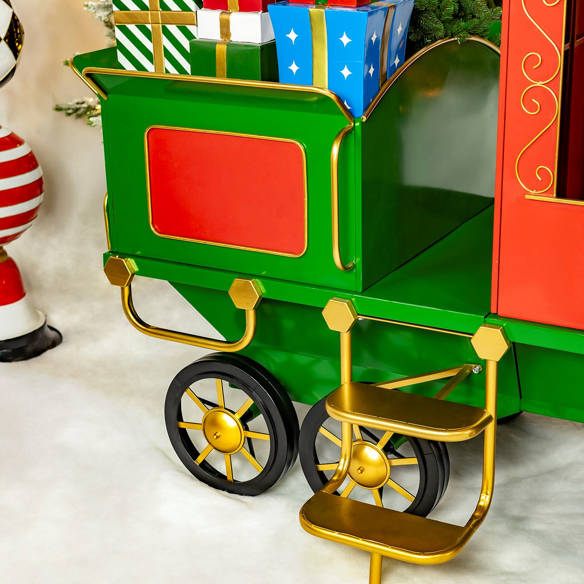 Green rear cart with red panel and gold trim beside the train car