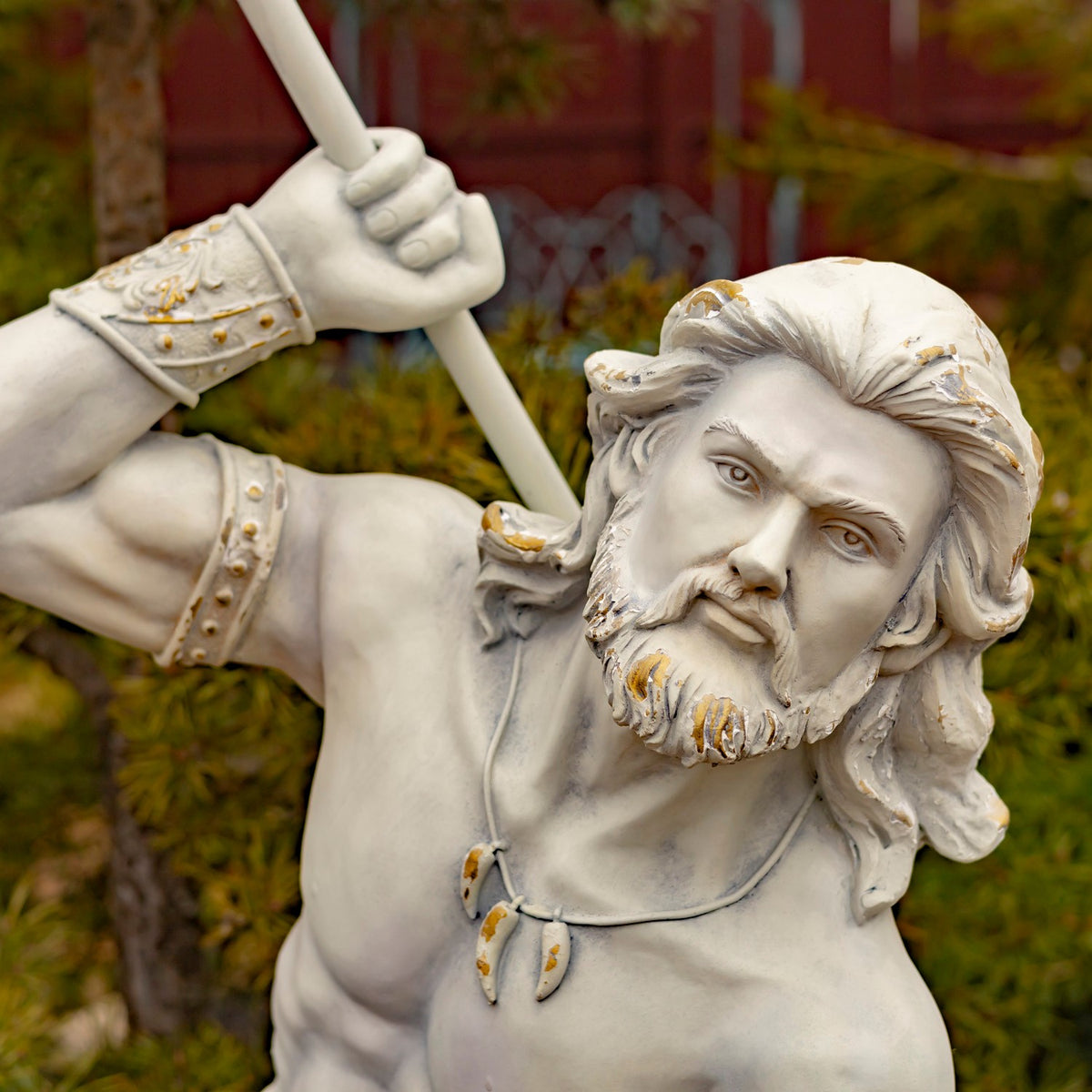 Close-up of the merman’s bearded face, raised hand, and decorative wrist cuff.