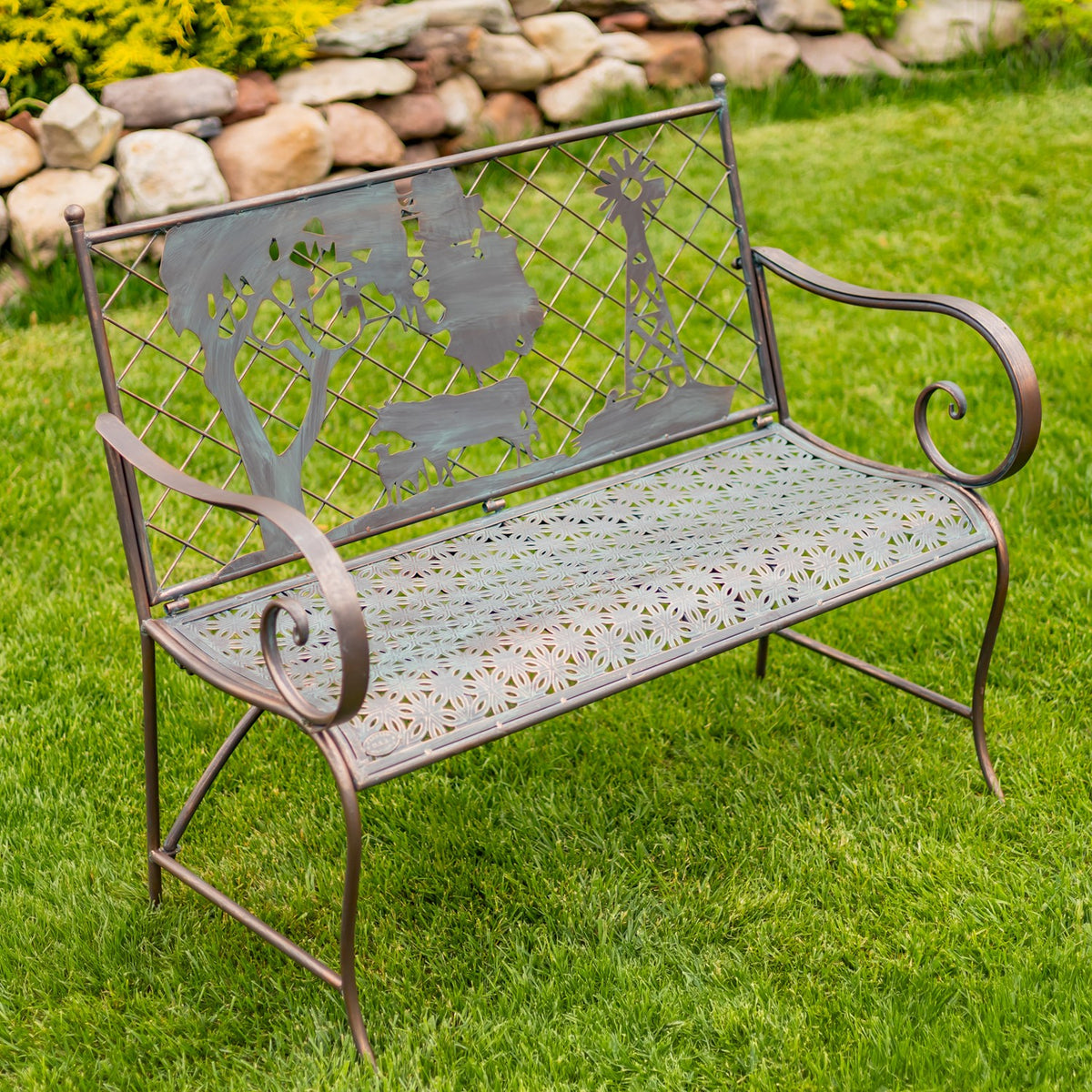 Metal garden bench with curled arms, a patterned seat, and cow and windmill cutouts on the back.