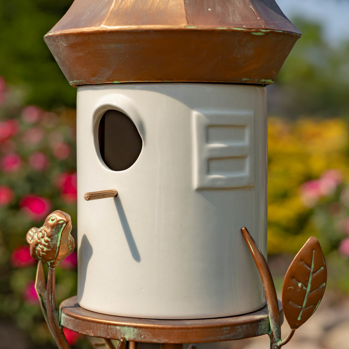 Angled view of the birdhouse showing its entrance hole, small perch, and raised side detail.