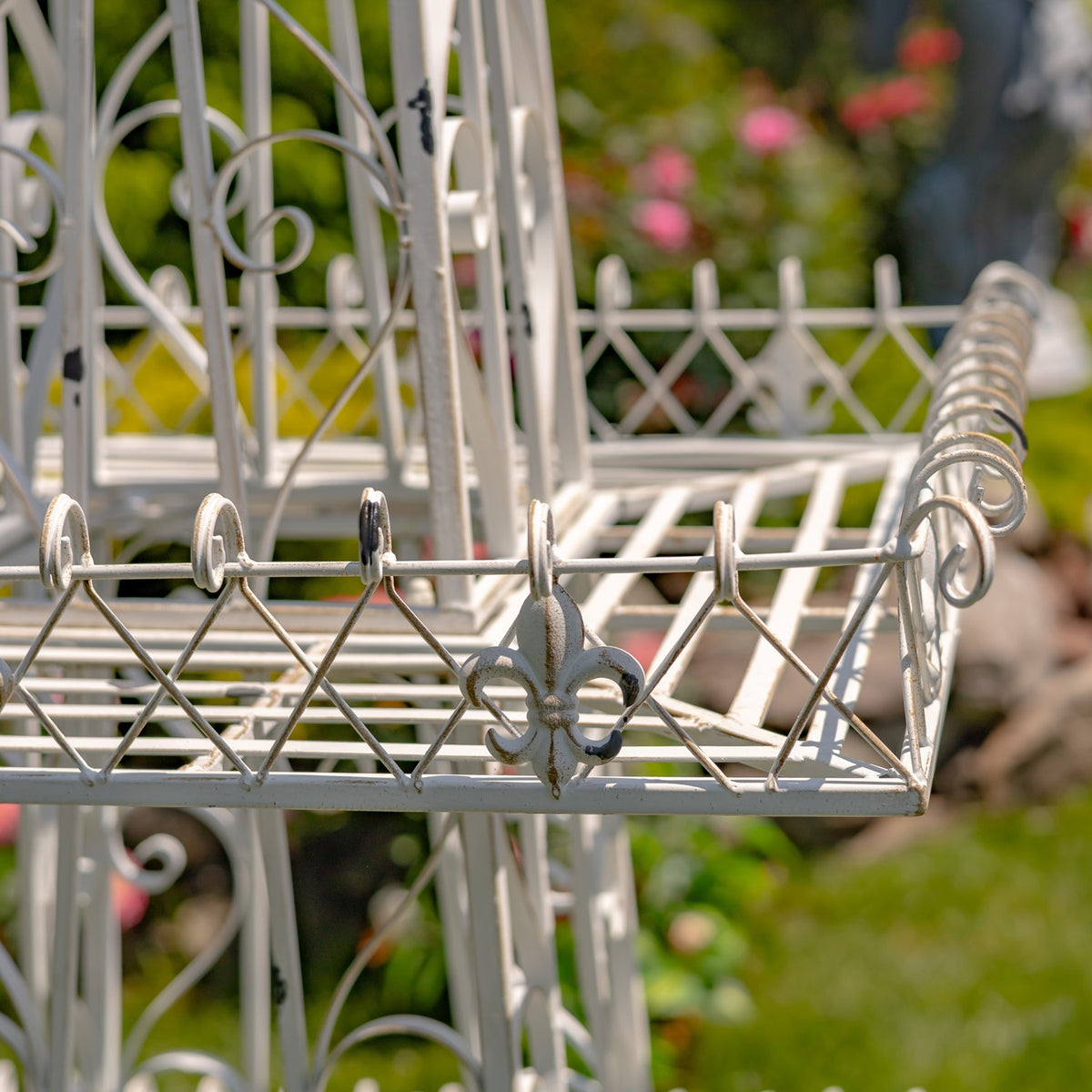 Close-up of the square tier’s wire railing, curled trim and fleur-de-lis ornament.