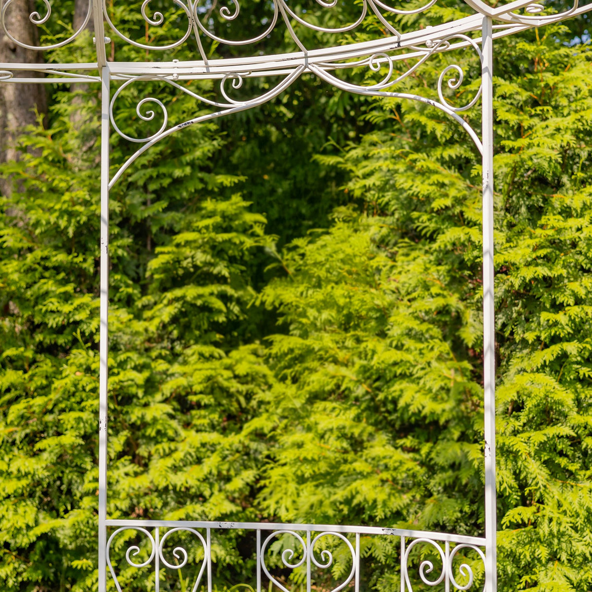 Close-up of white gazebo posts, upper scrollwork, and railing