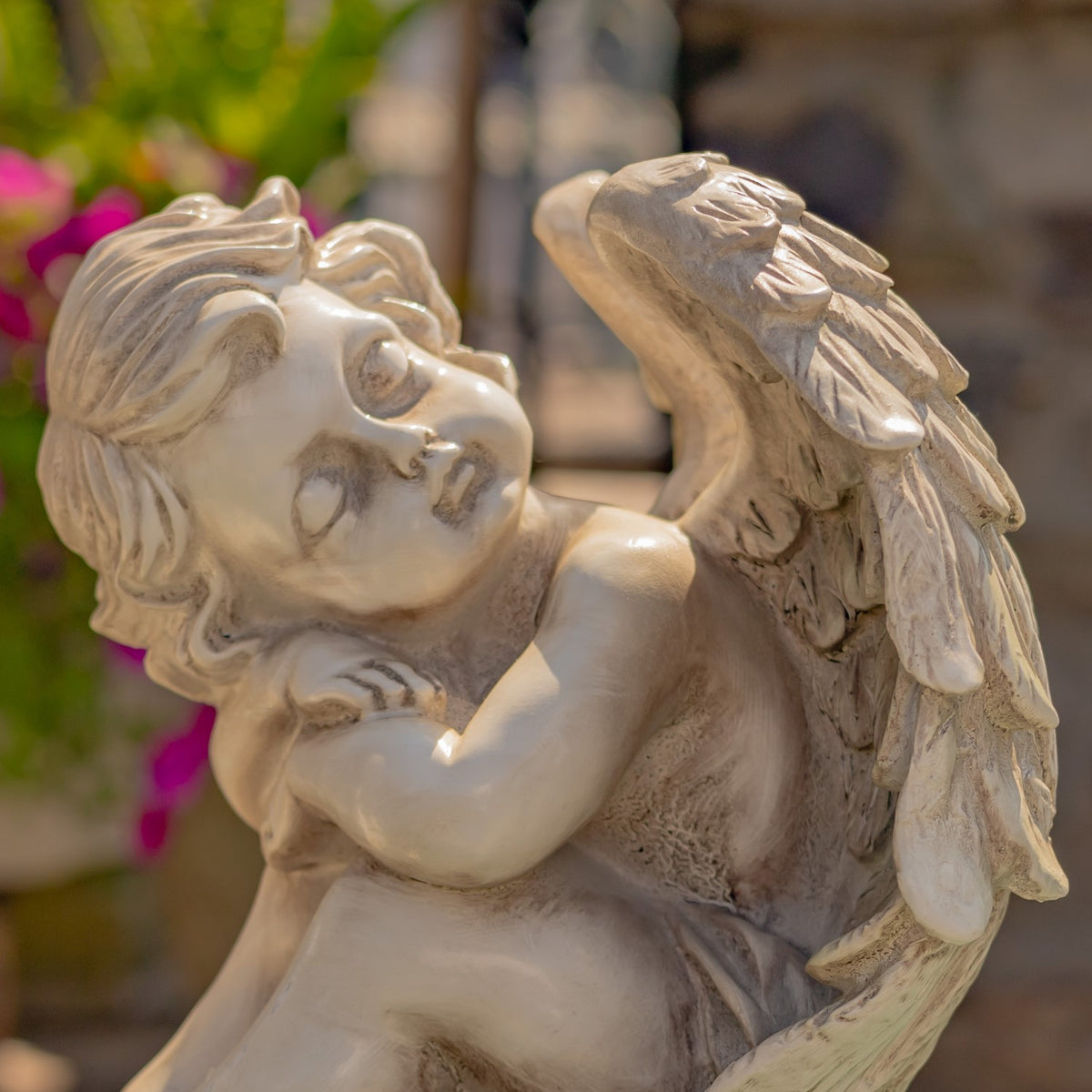 Side view of a cherub statue showing its sculpted wing
