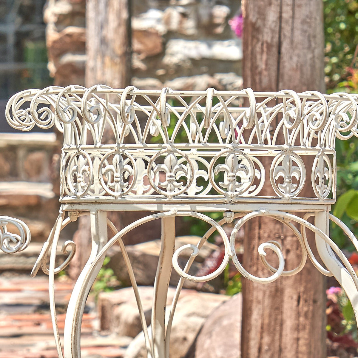 Close-up of the round basket, scrolling metalwork and curved legs on a plant stand.