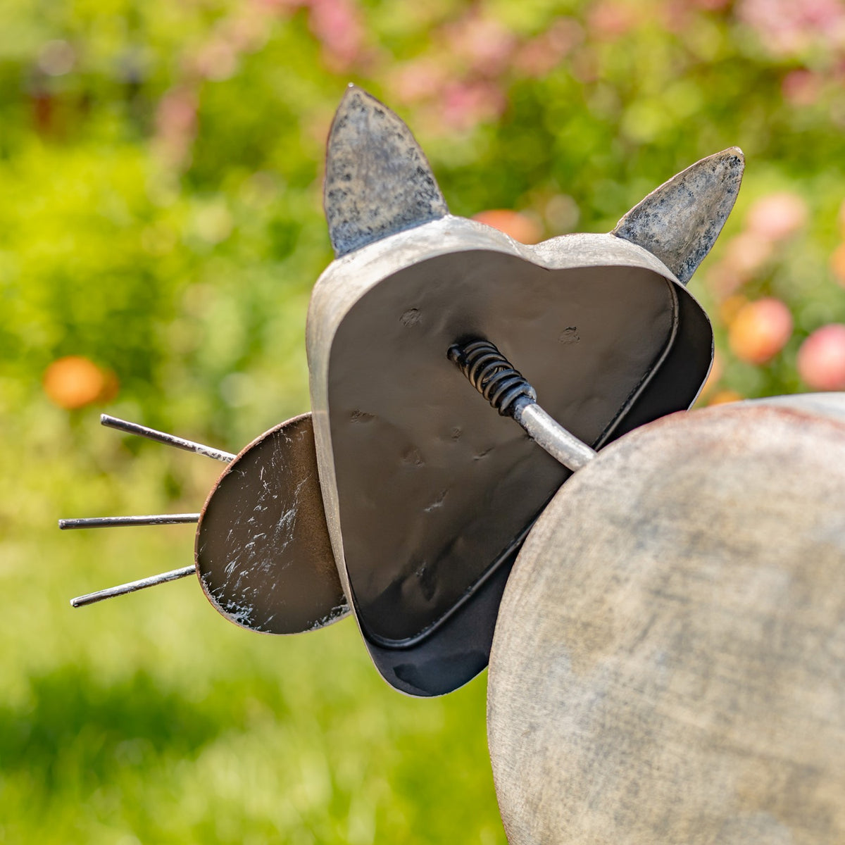 Close-up from below showing the spring connection beneath the cat planter's head