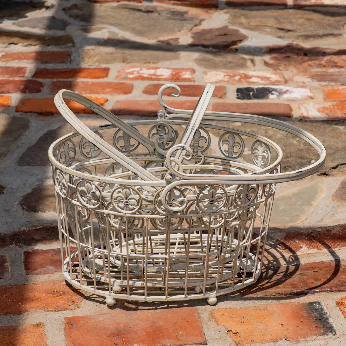 Pale metal basket viewed from above, with its arched handle folded across the open top.