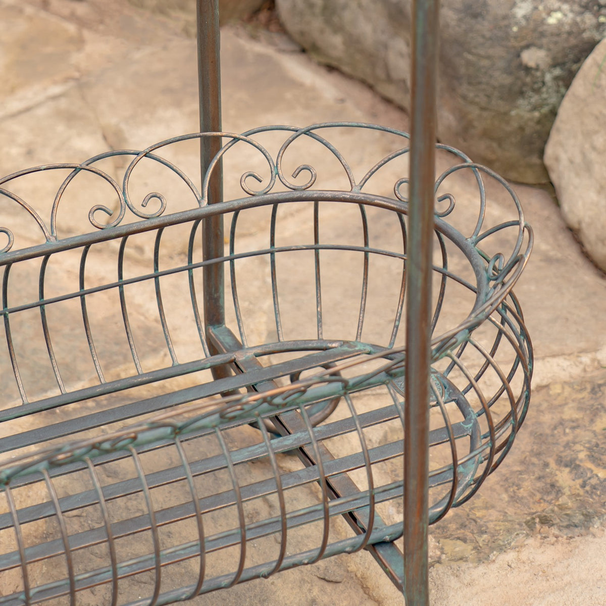 Close-up of the lower oval wire basket, showing its curved rim and decorative metal scrollwork.