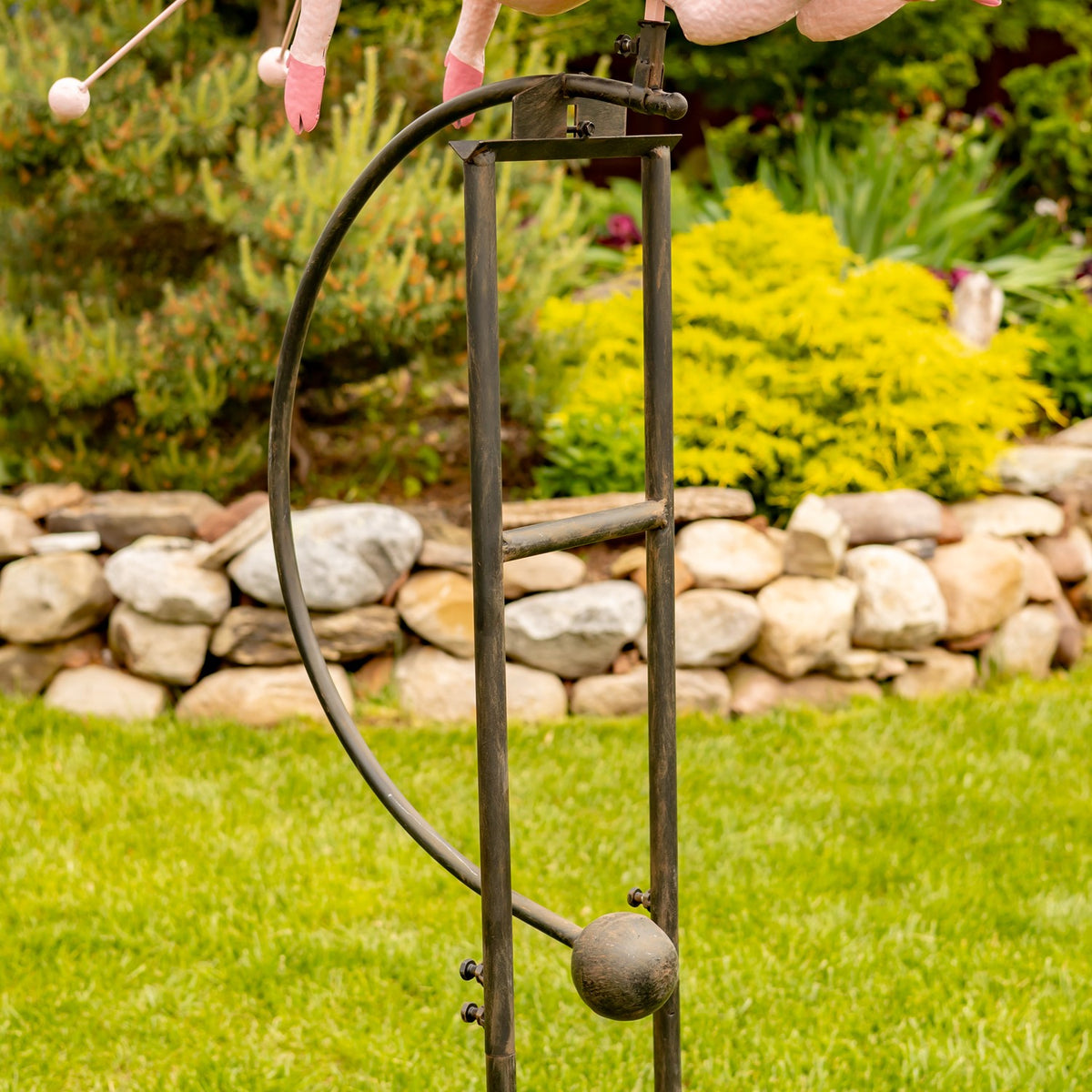 Close view of the dark metal garden stake and its pronged base
