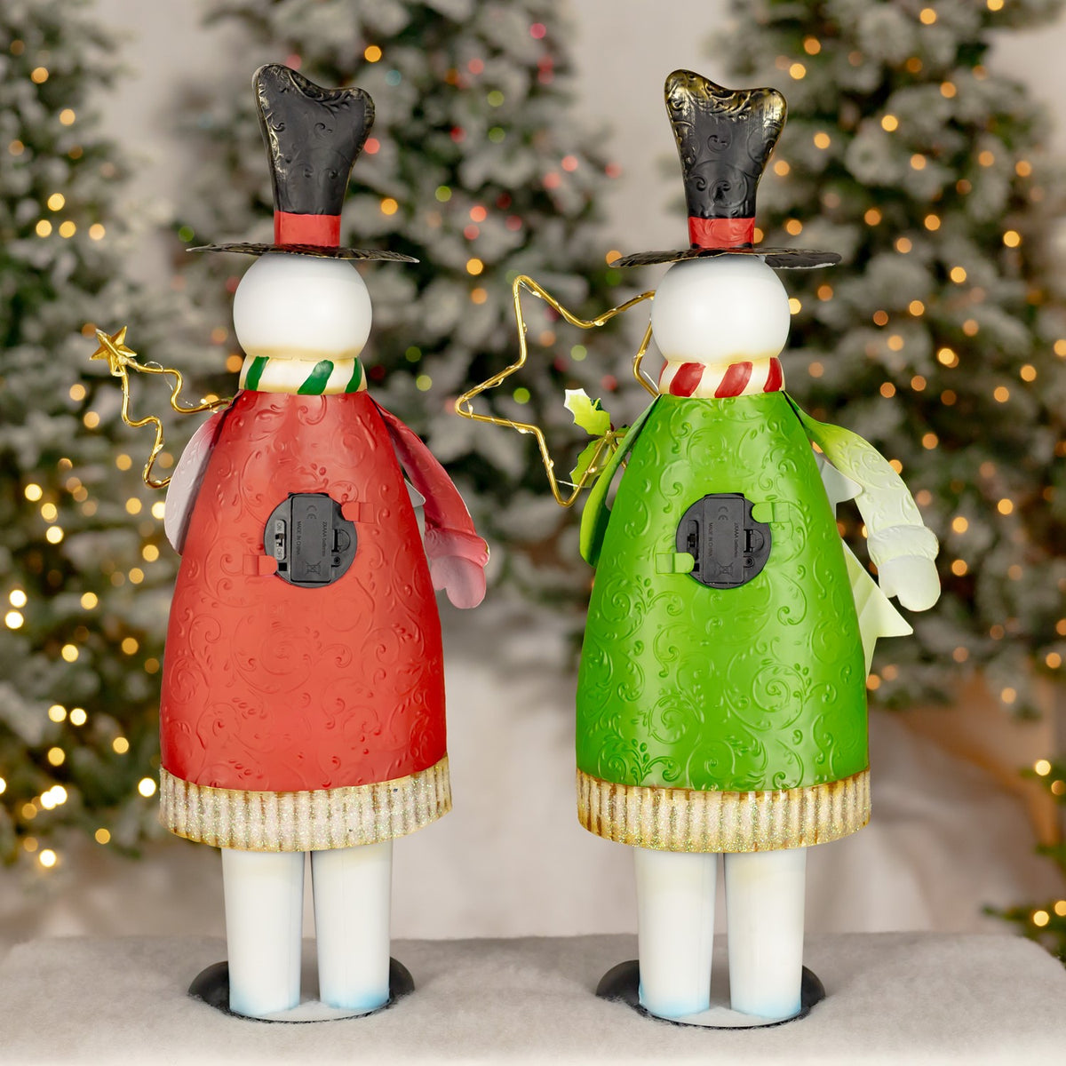 Two snowman decorations shown from behind, one in a red coat and one in a green coat.