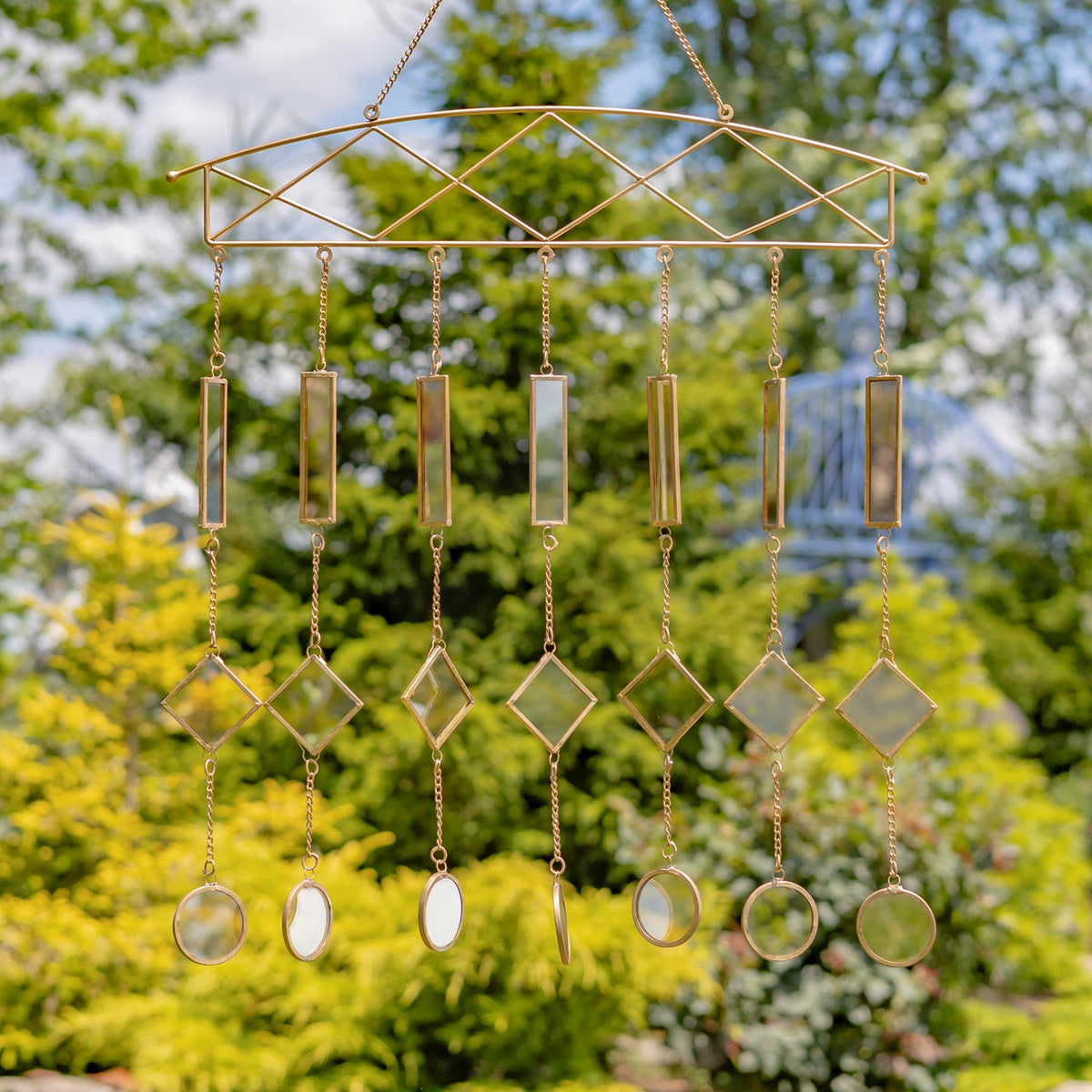 Gold-toned hanging chime with rows of rectangular, diamond-shaped, and round metal pieces.