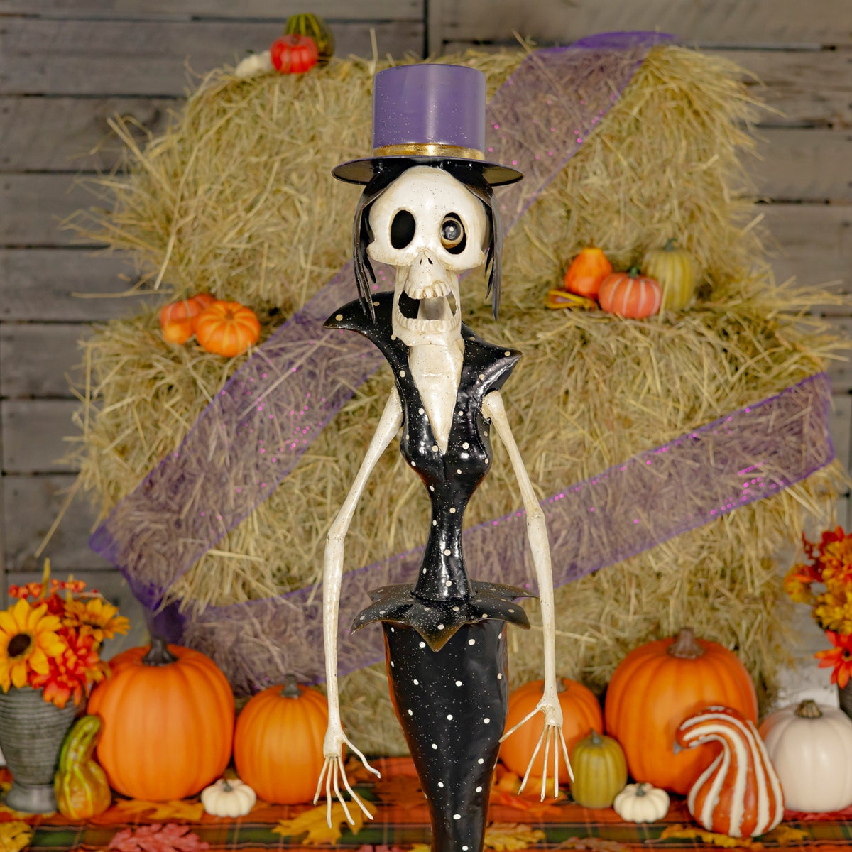 Close-up of a skeleton figurine wearing a purple top hat in an autumn display