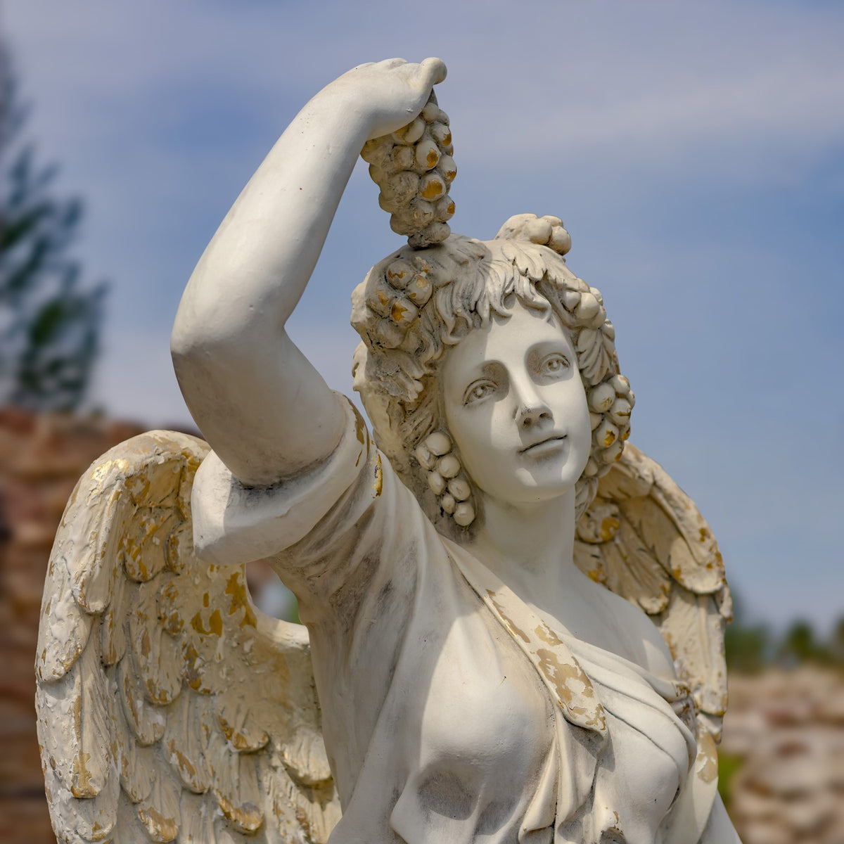 The angel raises one arm overhead, with a wing and draped clothing visible.