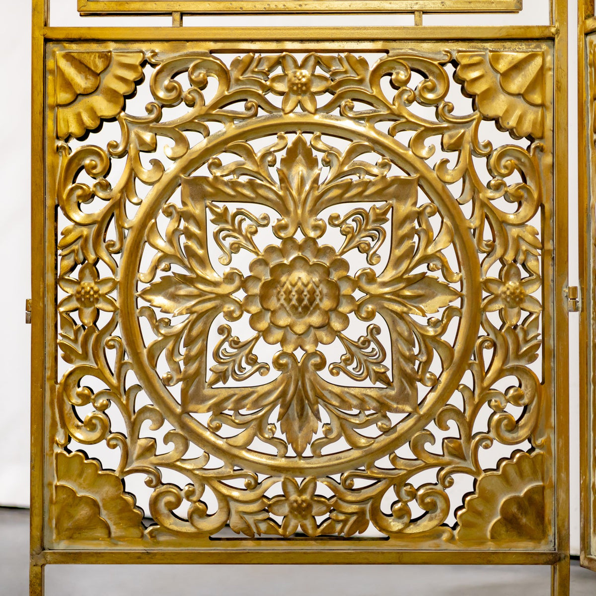 Intricate gold floral medallion and curling openwork fill the center of a screen panel.