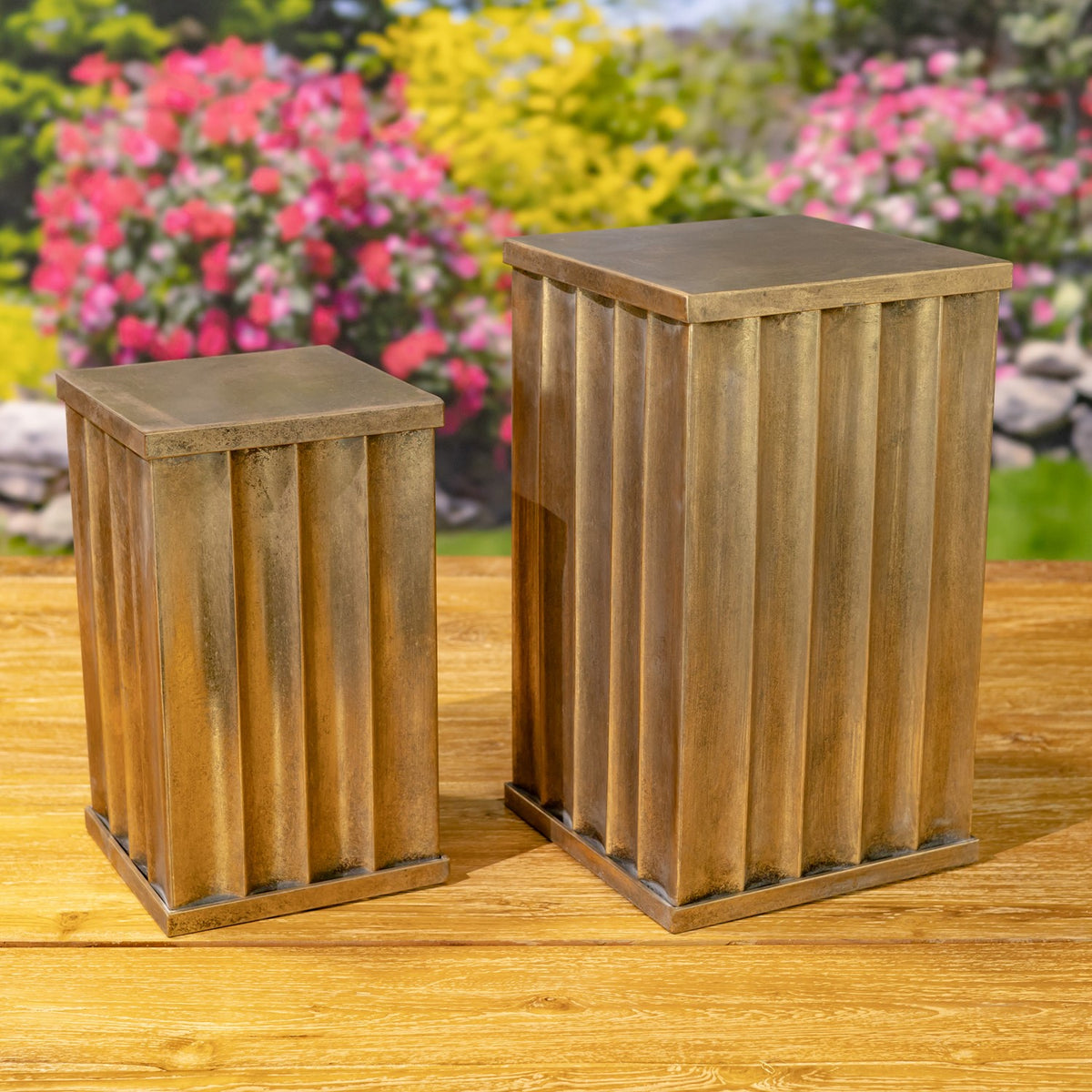 Two bronze-toned fluted pedestals of different heights displayed together.