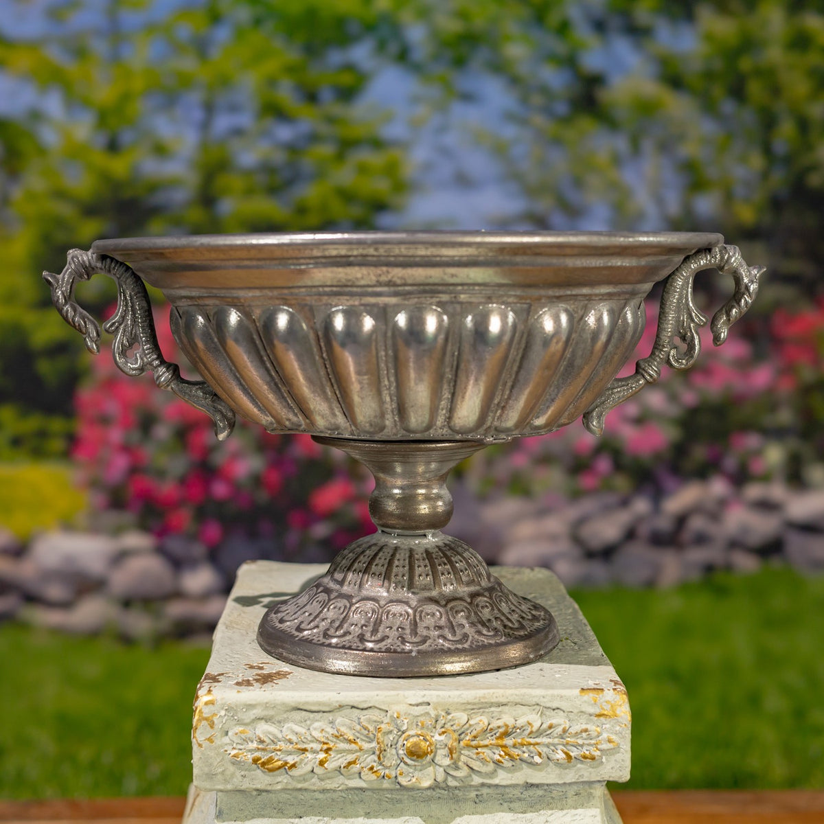 Frosted silver urn with a fluted bowl, sculpted handles, and an embossed pedestal base.