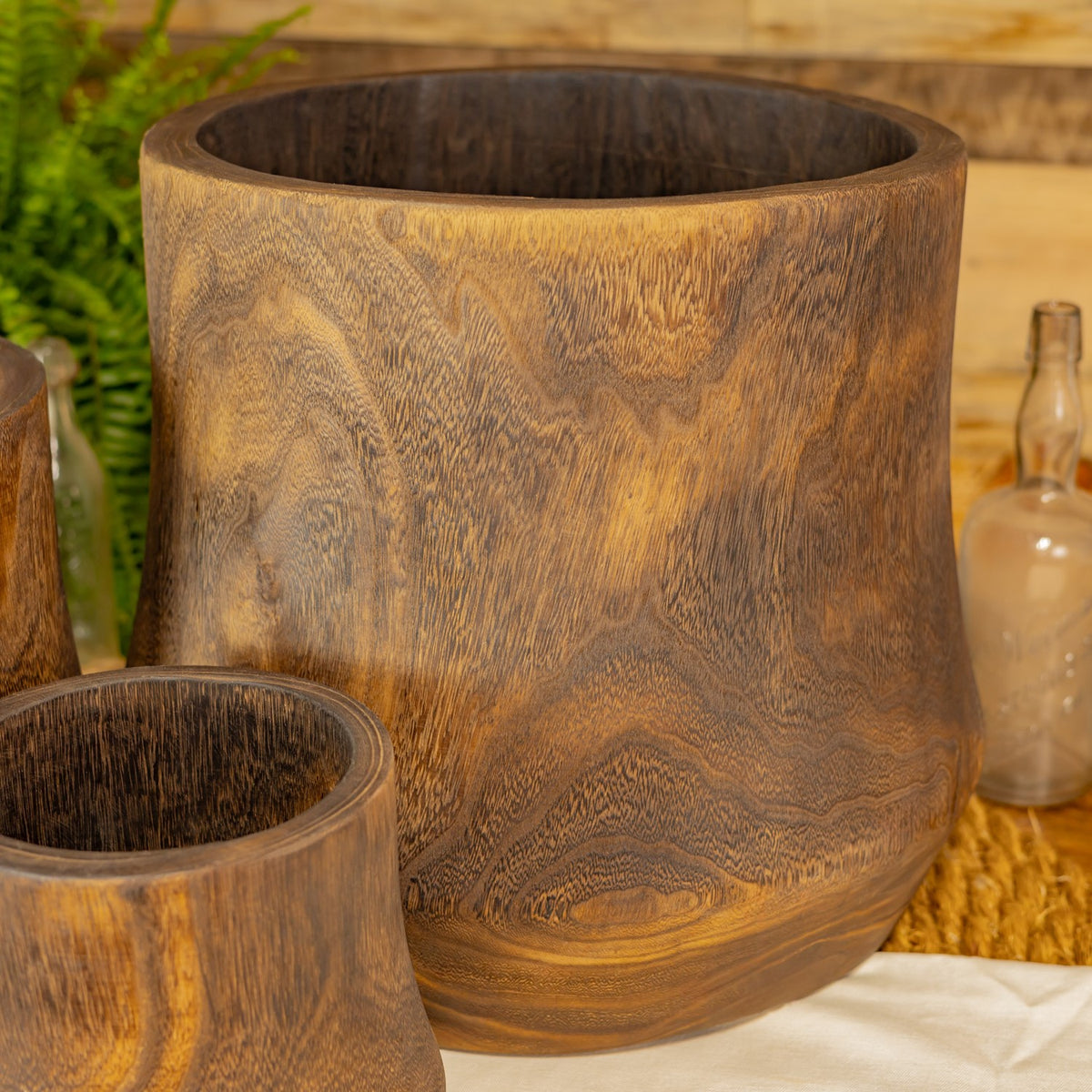 Close-up of the largest wooden bowl, showing its dark interior and swirling grain.